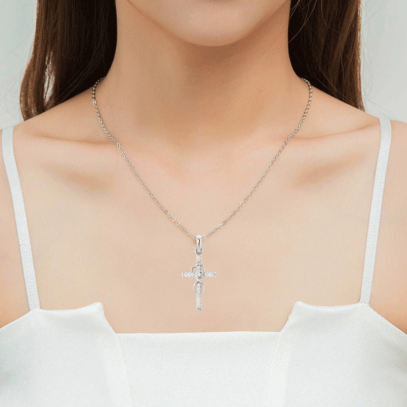 Diamond cross necklace worn on model